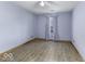 Cozy bedroom with light blue walls, wood-look flooring and a window with patterned curtains at 12249 E Harvest Glen Dr, Cumberland, IN 46229