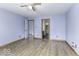 Light-filled bedroom featuring wood-look floors, and doorways to an adjacent room and bathroom at 12249 E Harvest Glen Dr, Cumberland, IN 46229