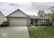 Charming single-story home with a well-manicured lawn and attached two-car garage at 12249 E Harvest Glen Dr, Cumberland, IN 46229