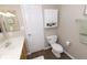 Clean bathroom featuring a white toilet, wooden vanity, and a convenient storage cabinet, offering practical functionality at 12678 Brewton St, Fishers, IN 46038