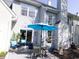 Exterior view of a home with a patio area featuring a blue umbrella, outdoor furniture, and manicured landscaping at 12678 Brewton St, Fishers, IN 46038