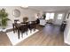 Open-concept living room and dining area with wood-look flooring and modern decor at 12678 Brewton St, Fishers, IN 46038
