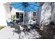 Serene patio featuring a glass table, comfortable seating, a blue umbrella, and lush landscaping at 12678 Brewton St, Fishers, IN 46038