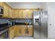 This kitchen features wooden cabinets, granite countertops, stainless steel appliances, and a tiled backsplash at 12820 University Cres # 3D, Carmel, IN 46032