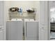 Laundry room features newer washer and dryer units, with shelf storage above for supplies at 12820 University Cres # 3D, Carmel, IN 46032
