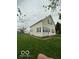 An angled view of the two-story house showing the yard and cream-colored siding at 137 S 2Nd Ave, Beech Grove, IN 46107