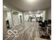 Open floor plan with gray floors leading into a kitchen with white cabinets at 137 S 2Nd Ave, Beech Grove, IN 46107
