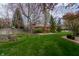 Expansive backyard featuring lush lawn, mature trees, flowering shrubs, and a charming pergola swing at 13797 Mill Stream Ct, Carmel, IN 46032