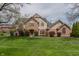 Charming two-story brick home featuring a well-manicured lawn and lush landscaping at 13797 Mill Stream Ct, Carmel, IN 46032