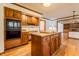 Open kitchen featuring an island with granite countertops, wood cabinetry, and stainless steel appliances at 13797 Mill Stream Ct, Carmel, IN 46032