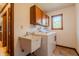 Functional laundry room with cabinets, utility sink, and window bringing in natural light at 13797 Mill Stream Ct, Carmel, IN 46032