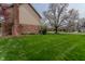 Lush green side yard of home featuring mature trees, brick, siding, and brick chimney at 13797 Mill Stream Ct, Carmel, IN 46032
