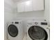 Well-equipped laundry room with front load washer and dryer with white cabinets above at 14117 Princewood Dr, Fishers, IN 46037