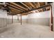Unfinished basement with white-wrapped walls and exposed ceiling beams, providing ample storage or the potential for finishing at 14872 Autumn View Way, Fishers, IN 46037