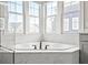 Soaking tub with elegant fixtures surrounded by marble tiling and a bay window at 14872 Autumn View Way, Fishers, IN 46037