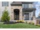 Close-up of a home's entrance with stone accents, a dark door, and a cozy, inviting porch at 14872 Autumn View Way, Fishers, IN 46037