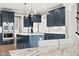 A designer kitchen with stainless steel appliances and blue cabinets, with modern lighting and a view of the dining area at 14872 Autumn View Way, Fishers, IN 46037