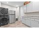 Efficient laundry room with stacked washer/dryer, utility sink, and ample cabinet storage at 14872 Autumn View Way, Fishers, IN 46037