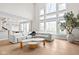 Bright living room with floor-to-ceiling windows, hardwood floors, and a comfortable white sectional sofa at 14872 Autumn View Way, Fishers, IN 46037