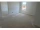 A spacious bedroom with white walls, two windows allowing ample light, and an open doorway at 1656 Winn Ct, Fortville, IN 46040