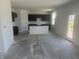 Unfinished kitchen with an island, dark brown cabinets, and plenty of natural light from the exterior door at 1656 Winn Ct, Fortville, IN 46040