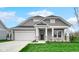 Beautiful home with a covered porch, gray siding, a well-manicured lawn, and a two-car garage at 16870 Imperial Ct, Fishers, IN 46040