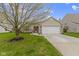 Charming brick home with a two-car garage and inviting front yard with mature tree and vibrant green lawn at 17072 Newberry Ln, Westfield, IN 46074