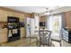Cozy eat-in kitchen featuring tan cabinets, black appliances, a glass-top dining table, and patio access at 17072 Newberry Ln, Westfield, IN 46074