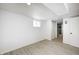 Well-lit basement featuring wood-look flooring, white walls, window and a partial view of an adjacent room at 2009 N Bosart Ave, Indianapolis, IN 46218
