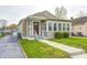 Charming bungalow with tan siding, a manicured lawn, and inviting front porch at 2009 N Bosart Ave, Indianapolis, IN 46218