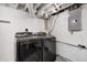 Basement laundry area with modern black front-load washer and dryer and exposed ceiling at 2009 N Bosart Ave, Indianapolis, IN 46218