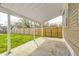 Covered back patio with concrete flooring, overlooking a fenced-in yard with green grass at 2009 N Bosart Ave, Indianapolis, IN 46218