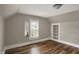 This bedroom features a built-in bookshelf, window and wood flooring at 221 N Munsie St, Indianapolis, IN 46229