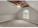 Cozy bedroom featuring sloped ceilings, a wooden beam accent, and a ceiling fan at 221 N Munsie St, Indianapolis, IN 46229
