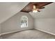 Cozy bedroom featuring sloped ceilings, a wooden beam accent, and a ceiling fan at 221 N Munsie St, Indianapolis, IN 46229