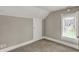 Neutral bedroom with gray walls, plush carpet, and a window letting in natural light at 221 N Munsie St, Indianapolis, IN 46229