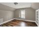 This bedroom features a window and wood flooring at 221 N Munsie St, Indianapolis, IN 46229