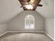 Cozy bedroom with sloped ceilings, carpet, and a large window for natural light at 221 N Munsie St, Indianapolis, IN 46229