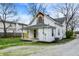Exterior view of a cozy two-story home with a well-manicured lawn and fresh gravel driveway at 221 N Munsie St, Indianapolis, IN 46229