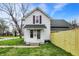 A cozy two-story home boasts a fresh green lawn and a newly constructed wooden fence at 221 N Munsie St, Indianapolis, IN 46229