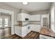 Bright kitchen featuring white cabinets, updated appliances, and access to other rooms at 221 N Munsie St, Indianapolis, IN 46229