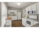 Bright kitchen featuring white cabinets, updated appliances, and a ceiling light fixture at 221 N Munsie St, Indianapolis, IN 46229