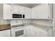 Close up on bright kitchen featuring white cabinets, updated appliances, and modern backsplash at 221 N Munsie St, Indianapolis, IN 46229