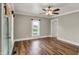 Living room with hardwood floors, ceiling fan, updated light fixture and fresh neutral paint at 221 N Munsie St, Indianapolis, IN 46229