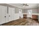 Living room with wainscoting, hardwood floors, ceiling fan, and easy access to other rooms at 221 N Munsie St, Indianapolis, IN 46229