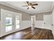 Living room with wainscoting, hardwood floors, ceiling fan, and French doors to the outside deck at 221 N Munsie St, Indianapolis, IN 46229
