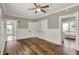 Living room with wainscoting, hardwood floors, ceiling fan, and many access doors at 221 N Munsie St, Indianapolis, IN 46229