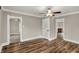 Open-concept living room featuring hardwood floors, ceiling fan, and easy access to other rooms at 221 N Munsie St, Indianapolis, IN 46229
