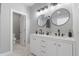 This bathroom features dual vanities, round mirrors, and marble floors at 2326 Guilford Ave, Indianapolis, IN 46205
