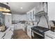 Stylish kitchen with stainless steel appliances, white cabinets, marble countertops, and modern pendant lighting at 2326 Guilford Ave, Indianapolis, IN 46205